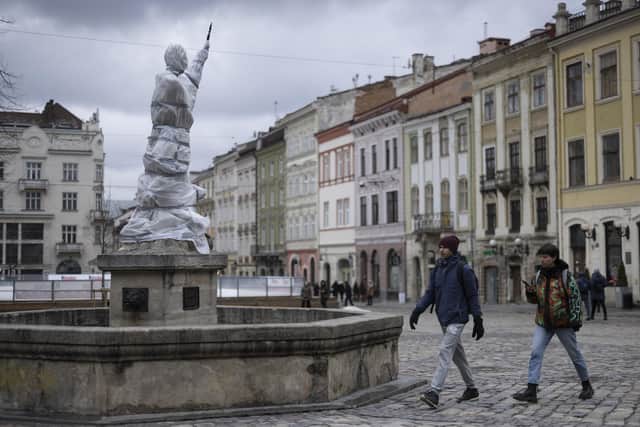 Statues are wrapped up around Lviv Town Hall. Volunteers are in the process of covering and wrapping statues and windows on many of the historically important buildings in the city. (Photo by Dan Kitwood/Getty Images)