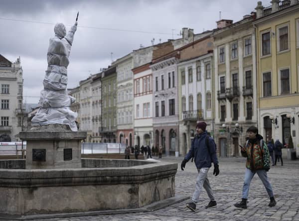 Statues are wrapped up around Lviv Town Hall. Volunteers are in the process of covering and wrapping statues and windows on many of the historically important buildings in the city. (Photo by Dan Kitwood/Getty Images)