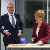 Scotland's First Minister Nicola Sturgeon (C) flanked by former Scottish National Investment Bank CEO Eilidh Mactaggart (R) and chair Willie Watt signs a visitors book at the bank's official launch at their headquarters on November 19, 2020 in Edinburgh, Scotland. (Photo by Andy Buchanan - WPA Pool/Getty Images)