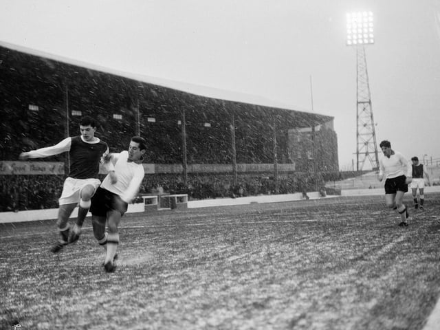 Players brave a snow-covered pitch during a Hibs v Clyde match at Easter Road in December 1964.