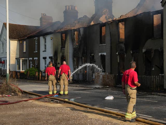 Houses in Wennington, east London, burn after grass fires spread into the village during the heatwave earlier this week (Picture: Carl Court/Getty Images)