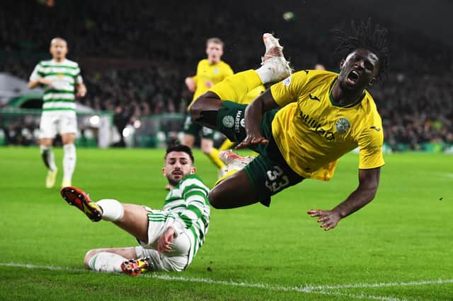 Hibs debutant Rocky Bushiri is fouled by Greg Taylor of Celtic.