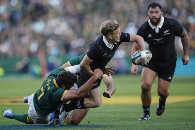 New Zealand's fly-half Damian McKenzie (C) offloads as he is tackled by South Africa's Ben-Jason Dixon (L) during the Rugby Championship match at Ellis Park. (Photo by PHILL MAGAKOE/AFP via Getty Images)