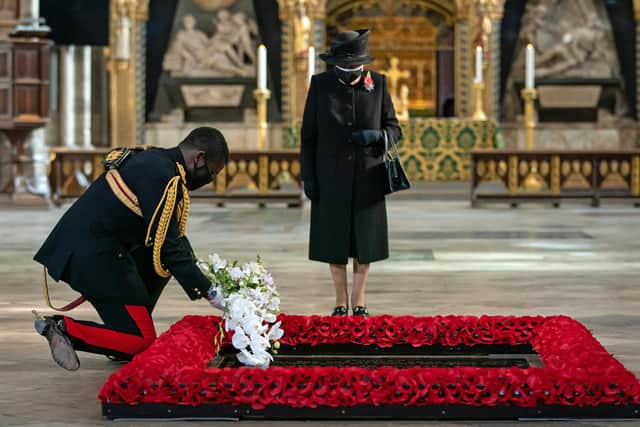 The Queen's Equerry, Lieutenant Colonel Nana Kofi Twumasi-Ankrah, places a bouquet of flowers at the grave of the Unknown Warrior on behalf of Queen Elizabeth II (centre) during a ceremony in London's Westminster Abbey.