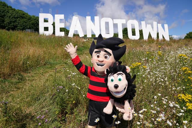 Dennis the Menace stands in front of a giant sign erected at Dundee Law renaming the city of Dundee to Beanotown to mark the start of the Dundee Bash Street Festival, which celebrates the city's comic book heritage. Designers have taken their inspiration from the famous Hollywood sign, the sign is six-metres high by 38-metres long and will be seen from around the city and across the Tay for the duration of the festival. Picture date: Friday July 15, 2022.