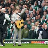 Scottish singer Daniel Rooney (right) playing at half time during the cinch Premiership match at Celtic Park. He was called up as a last-minute replacement for Olly Murs on Friday night. Picture: Andrew Milligan/PA Wire