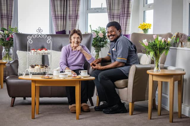 Resident and carer at HC-One care home enjoying coffee and cakes