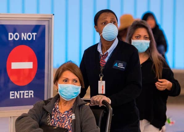 Passengers wear face masks to protect against Covid-19 after arriving at the LAX airport in Los Angeles (Getty Images)