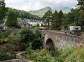 KILLIN, SCOTLAND The historic stone bridge of the A827 road above the river and falls of  Dochart in Killin, Scotland. Copyright (c) 2020 Mino Surkala/Shutterstock.