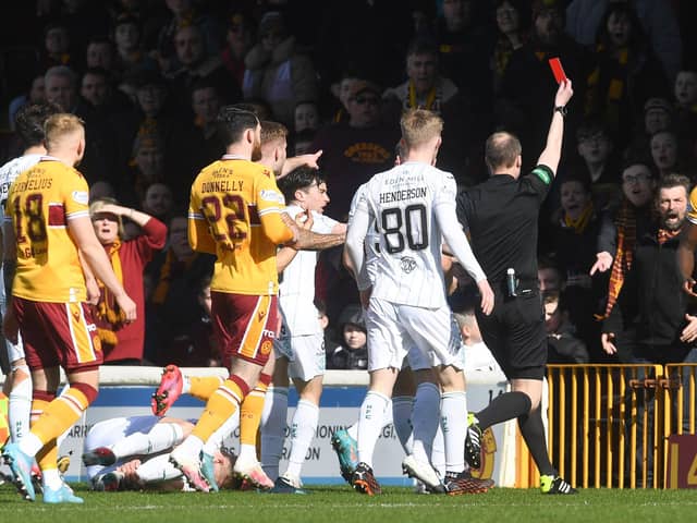 Motherwell's Bevis Mugabi (R) is sent off by referee Willie Collum.
