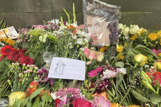 Flowers, cuddly toys, candles, heartfelt messages, paintings and drawings, balloons, coins -- people have left all sorts of tributes to the Queen in the gardens at Holyrood palace, expressing how much she meant to them. Picture: Ilona Amos