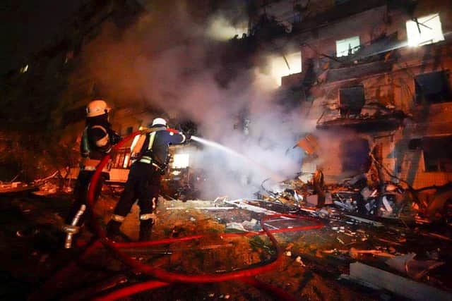 Firefighters hose down burning burning debris in front of a damaged building following a rocket attack on the city of Kyiv in Ukraine. Picture: Ukrainian Police Department Press Service via AP