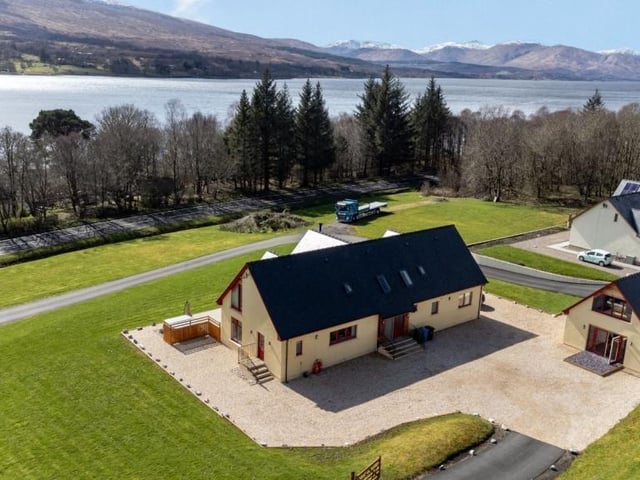 Aerial view of property and views across Loch Eil and distant mountains.