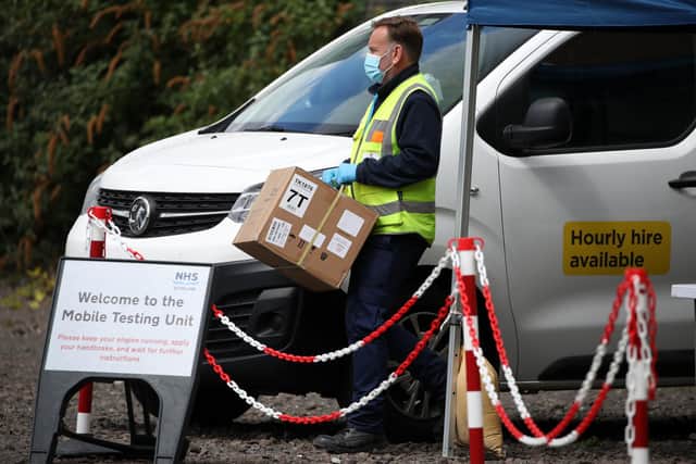 Staff from the Scottish Ambulance Service carry boxes of test kits from a van at a Covid Mobile Testing Unit in a car park in the Pollokshields area of Glasgow. Glasgow and Moray remain in Level 3 restrictions despite the rest of mainland Scotland moving to Level 2 on Monday. Picture date: Tuesday May 18, 2021.
