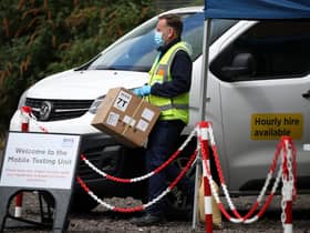 Staff from the Scottish Ambulance Service carry boxes of test kits from a van at a Covid Mobile Testing Unit in a car park in the Pollokshields area of Glasgow. Glasgow and Moray remain in Level 3 restrictions despite the rest of mainland Scotland moving to Level 2 on Monday. Picture date: Tuesday May 18, 2021.