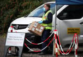 Staff from the Scottish Ambulance Service carry boxes of test kits from a van at a Covid Mobile Testing Unit in a car park in the Pollokshields area of Glasgow. Glasgow and Moray remain in Level 3 restrictions despite the rest of mainland Scotland moving to Level 2 on Monday. Picture date: Tuesday May 18, 2021.