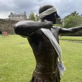 'Archie', the Roman archer statue who guards the River Esk at Musselburgh, has been adorned with white ribbon by locals worried about the threatened concrete barrier (Picture: Steven Robertson)