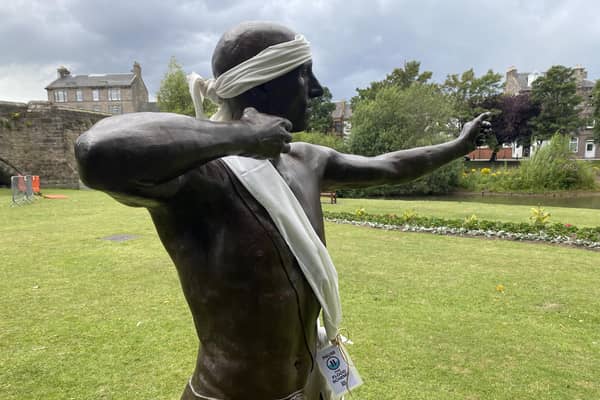 'Archie', the Roman archer statue who guards the River Esk at Musselburgh, has been adorned with white ribbon by locals worried about the threatened concrete barrier (Picture: Steven Robertson)