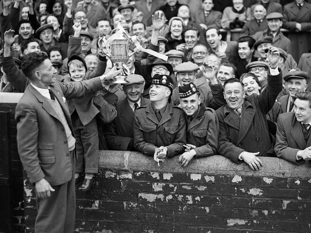 Hearts groundsman Mathie Chalmers shows the Scottish Cup to a section of the crowd at Tynecastle in 1956. Hearts had just beaten Celtic at Hampden Park in the Scottish Cup final.