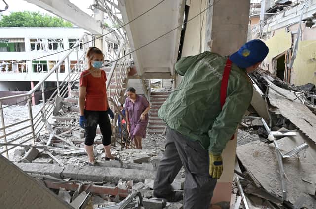 Teachers and staff members remove debris in the MV Lomonosov gymnasium in the centre of the Ukrainian city of Kharkiv, after it was hit by a Russian missile (Picture: Sergey Bobok/AFP via Getty Images)