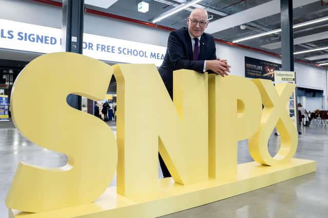 First Minister John Swinney poses for photographs alongside his party’s logo at the SNP conference in Aberdeen (Picture: Jane Barlow/PA)
