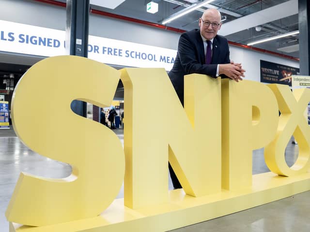 First Minister John Swinney poses for photographs alongside his party’s logo at the SNP conference in Aberdeen (Picture: Jane Barlow/PA)