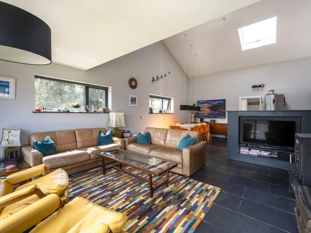 The modern kitchen, dining area and living room are all in one open place space.