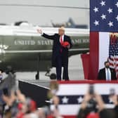 President Donald Trump tosses hats into the crowd as he arrives for a campaign rally at the Altoona-Blair County Airport in Martinsburg