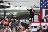President Donald Trump tosses hats into the crowd as he arrives for a campaign rally at the Altoona-Blair County Airport in Martinsburg