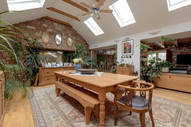 The light-filled dining area has a vaulted ceiling with exposed roof beams and a wooden floor
