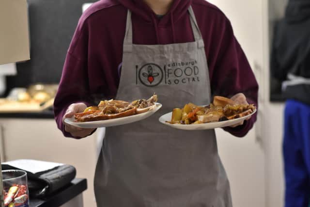 A young person carrying plates of food.