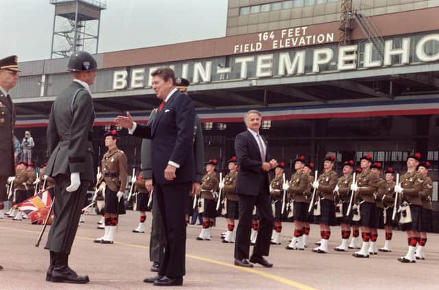 The then US President Ronald Reagan reviews Scottish soldiers after landing at Berlin Tempelhof Airport in 1987 before giving a speech near the Berlin wall at which he urged Soviet leader Mikhail Gorbachev to destroy it (Picture: Mike Sargent/AFP via Getty Images)