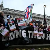Protesters wave Israeli flags and hold photos of people held hostage by Palestinian militant group Hamas in Gaza, during a demonstration outside Downing Street last week. (Photo by JUSTIN TALLIS / AFP) (Photo by JUSTIN TALLIS/AFP via Getty Images)