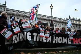 Protesters wave Israeli flags and hold photos of people held hostage by Palestinian militant group Hamas in Gaza, during a demonstration outside Downing Street last week. (Photo by JUSTIN TALLIS / AFP) (Photo by JUSTIN TALLIS/AFP via Getty Images)