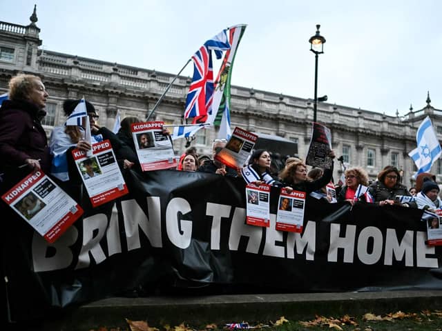 Protesters wave Israeli flags and hold photos of people held hostage by Palestinian militant group Hamas in Gaza, during a demonstration outside Downing Street last week. (Photo by JUSTIN TALLIS / AFP) (Photo by JUSTIN TALLIS/AFP via Getty Images)
