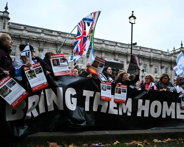 Protesters wave Israeli flags and hold photos of people held hostage by Palestinian militant group Hamas in Gaza, during a demonstration outside Downing Street last week. (Photo by JUSTIN TALLIS / AFP) (Photo by JUSTIN TALLIS/AFP via Getty Images)