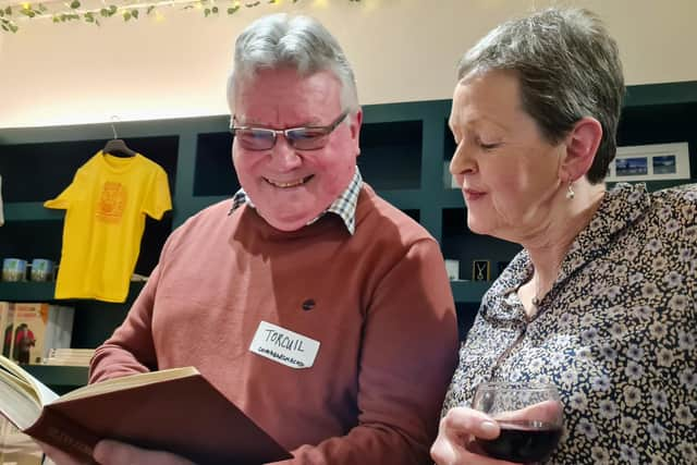 An Taigh Cèilidh has locally donated literature for visitors to enjoy, as we see traditional Gaelic singer Torquil Macleod and Susanne doing so in this photo.