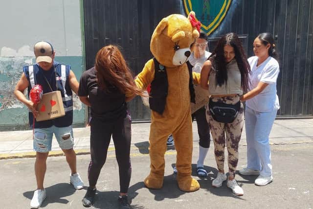 Undercover police squad members wishing to keep their anonymity pose at the doors of their headquarters in the district of San Martin in Lima, re-enacting a drug control operation gaining access as a Valentine's Day bear delivering a fake love surprise to raid and arrest drug dealers on Valentine's Day.