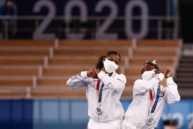 Simone Biles, right, and team-mate Jordan Chiles celebrate on the podium after the USA won Olympic silver in the artistic gymnastics women's team final. Picture: AFP via Getty Images