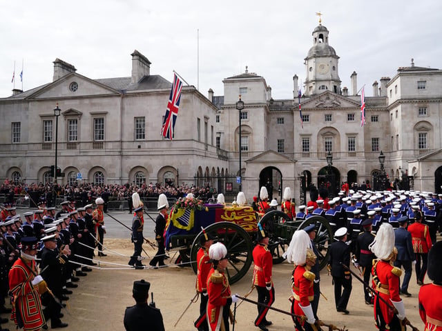 The State Gun Carriage carries the coffin of Queen Elizabeth II, draped in the Royal Standard with the Imperial State Crown and the Sovereign's orb and sceptre, in the Ceremonial Procession following her State Funeral at Westminster Abbey, London. Picture date: Monday September 19, 2022.