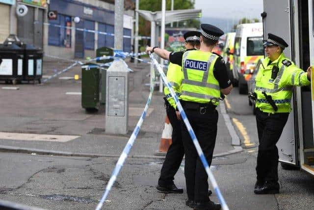 Police Scotland officers at a murder scene.