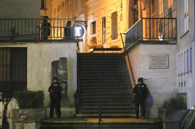 Police officers stay in position at stairs named 'Theodor Herzl Stiege' near a synagogue after gunshots were heard, in Vienna, Monday, Nov. 2, 2020.