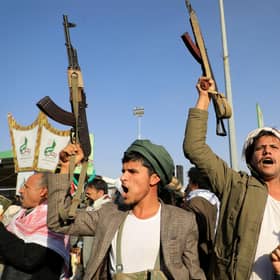 Houthi fighters brandish their weapons during a protest following US and British air strikes on targets in Yemen (Picture: Mohammed Huwais/AFP via Getty Images)