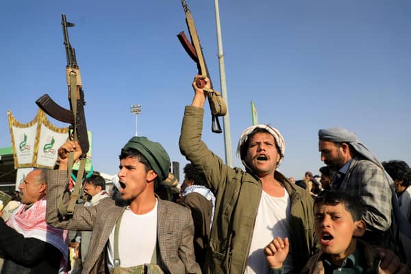 Houthi fighters brandish their weapons during a protest following US and British air strikes on targets in Yemen (Picture: Mohammed Huwais/AFP via Getty Images)