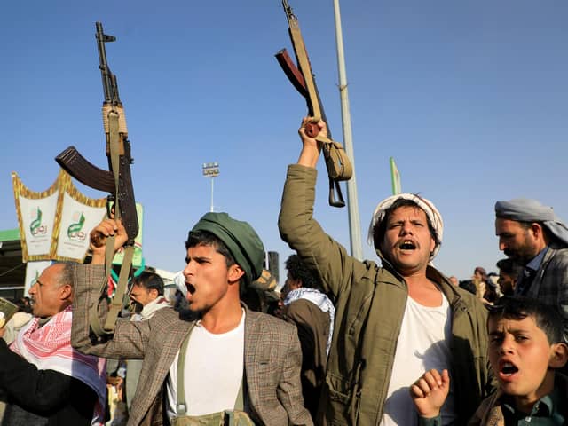Houthi fighters brandish their weapons during a protest following US and British air strikes on targets in Yemen (Picture: Mohammed Huwais/AFP via Getty Images)