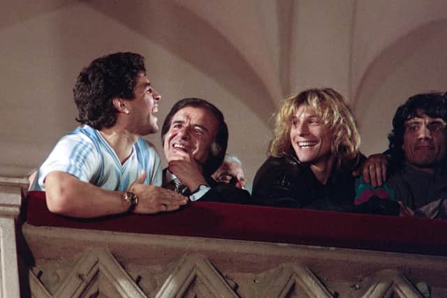 Argentinian ace Diego Maradona (L) flanked by (L to R) former Argentina's president Carlos Menem and footballers Claudio Caniggia and Hector Enrique, smiles from the balcony of Casa Rosada in Buenos Aires after their return from the 1990 World Cup on July 9, 1990.