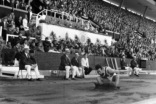 The Royal Family and the crowd watch as Wales' Lynn Davies completes his long jump to take the gold medal at the Commonwealth Games in Edinburgh in 1970.