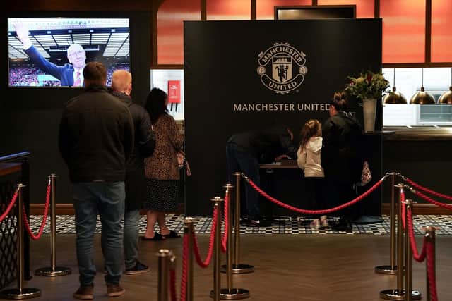 Visitors sign a book of condolence for Sir Bobby Charlton in the International Suite at Old Trafford.
