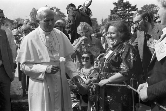 A local woman gives Pope John Paul II a flower at St Joseph's hospital, in Rosewell.