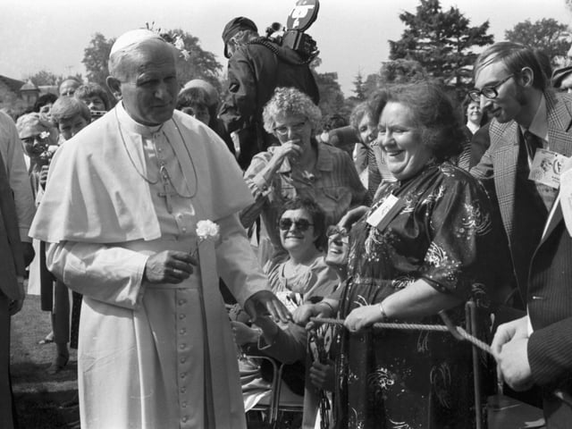A local woman gives Pope John Paul II a flower at St Joseph's hospital, in Rosewell.